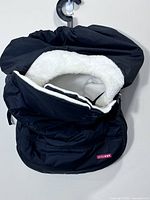 Front view of black Skip Hop car seat cover with fleece-lined opening