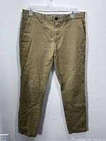 Full front view of khaki chino pants hanging