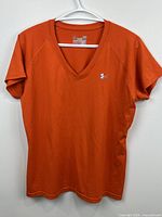 Front view of orange Under Armour women's V-neck T-shirt