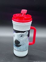 Full view of travel mug showing polar bear graphic, handle, lid