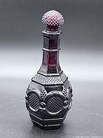 Full view of ruby-red Avon Cape Cod decanter with stopper