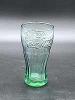 Full view of the single green-tinted Coca-Cola glass