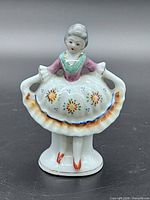 Front view of lady figurine holding skirt