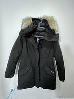 Full front view of black Canada Goose Rossclair parka with fur-trimmed hood on hanger