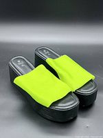 top angle showing both sandals, neon green uppers, black platforms