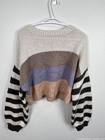 Front view of colour-blocked knit sweater on hanger