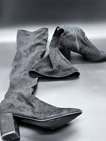 Both boots laid flat showing exterior, heel shape and faux suede texture