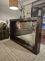 Front angled view of rectangular mirror showing walnut distressed wood frame and antiqued glass