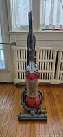 Front view of Dyson DC25 upright vacuum standing on hardwood floor