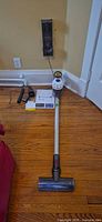 Full view of Dyson V7 vacuum assembled with motorhead, wall dock mounted, charger connected