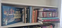 Shelf showing Fix-It-Yourself Manual, group of small hardbacks/paperbacks, Shakespeare set, Reader’s Digest animal titles