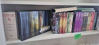 Shelf view showing approximately 20 DVDs including Memoirs set, Heeere’s Johnny box, assorted singles