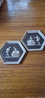 Pair of hexagonal plaster plaques on wood floor
