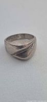 Front view of sterling silver sculpted signet ring showing diagonal ridge design
