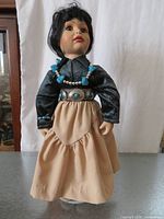 Front view of doll showing attire and accessories