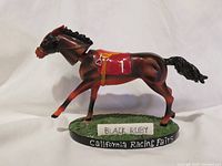 Left side view of Black Ruby bobblehead on base