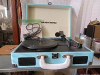 Overall view of blue Musitrend suitcase turntable open on table