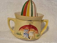 Complete juicer assembled, showing cup, reamer, twin handles, kitten design