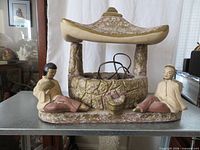 Front view of plaster pavilion lamp with two figures