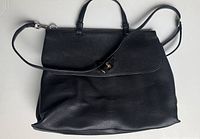 Front view showing overall bag shape, top handle and shoulder strap