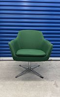 Front view of green swivel lounge chair showing overall design and upholstery