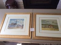 Both framed prints side by side on table showing overall lot