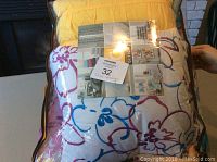 Twin comforter bedding set inside original sealed plastic packaging showing floral design and product tag indicating Intelligent Design brand.