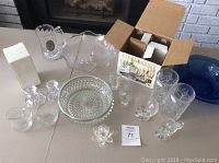 Full overview of glass and crystal serving dishes, various shapes and sizes including boxed items, cream and sugar sets, and candle holders.