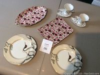 Overall view of 8 pieces including two Fritz and Floyd luncheon plates with crane design, two floral English Chintz rose pattern plates, two Elisa butterfly pattern demi tasse cups with matching extended saucers.