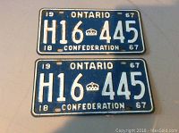 Pair of 1967 Ontario license plates showing the front with white embossed letters H16 445 on blue background, featuring a crown and 'CONFEDERATION' text.
