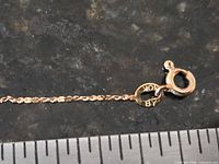 Close-up of spring ring clasp and 10K hallmark tag on gold chain
