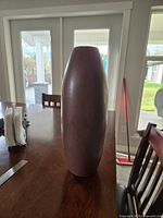 Full view of tall cylindrical brown ceramic vase on table