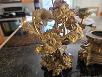 Close view of gilt floral bouquet with candle socket details