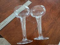 Two Rosenthal hollow stem champagne glasses beside ruler