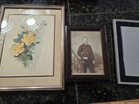 Two framed images and one empty frame side by side