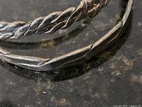 Close-up of twisted rope and hammered bangles showing design detail and silver surface