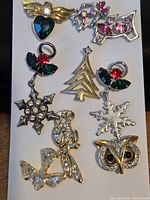 All eight lapel pins laid out on white card