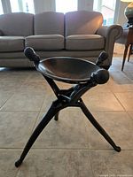 Full view of carved wooden tripod bowl in room lighting