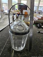 Full view of jar with lid and handle, ruler for scale