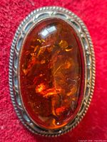 Front view showing amber cabochon and silver border