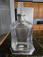 Front view of glass decanter with pewter base and spiral crystal stopper