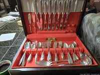Open chest showing entire flatware set in red felt lining