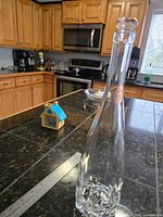 Full view of empty Gérard Bertrand wine bottle standing on counter
