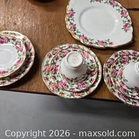 Group showing all china pieces including serving plate, stacked cups, saucers and plates