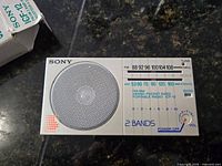 Front view of Sony ICF-12 radio showing speaker, tuning scale, controls