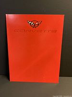 Front cover red with Corvette crossed-flags emblem and embossed model name
