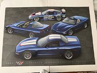 Poster depicting four blue 2004 Chevrolet Corvette Commemorative Edition cars with logo and caption