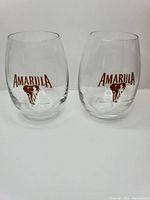 Two Amarula branded stemless glasses front view displaying logos