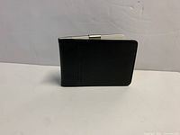 Unwrapped sample wallet standing to show exterior and clip spine