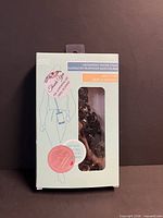 Front of sealed box showing black chain strap through window